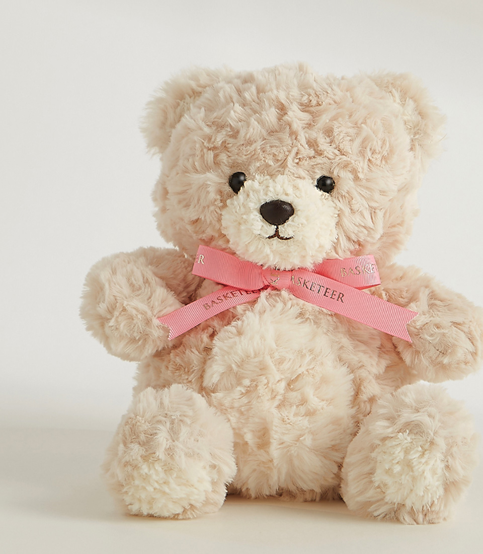 Soft beige teddy bear with a pink ribbon, featuring a plush and huggable design, perfect for gifts and cuddles.