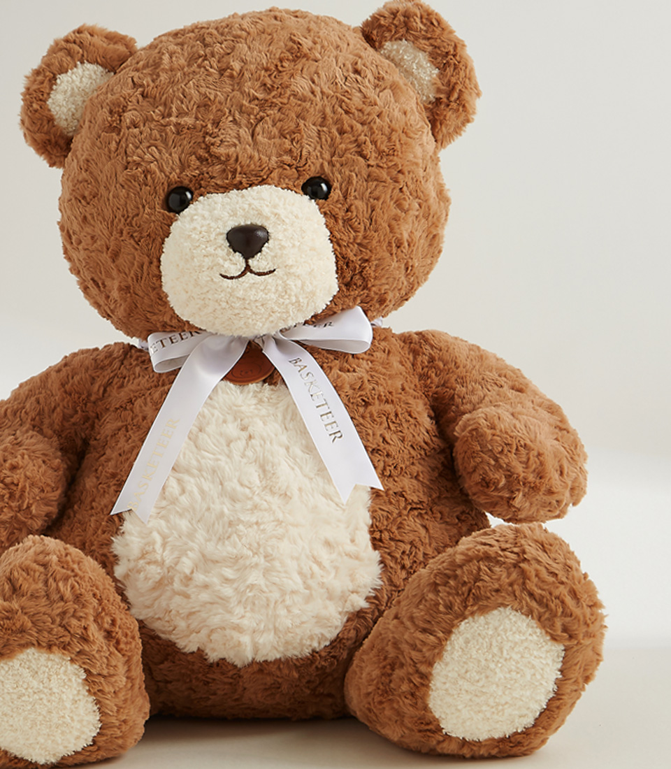 Large brown plush teddy bear with a white belly and a white ribbon, soft and huggable, perfect for gifting and snuggles.