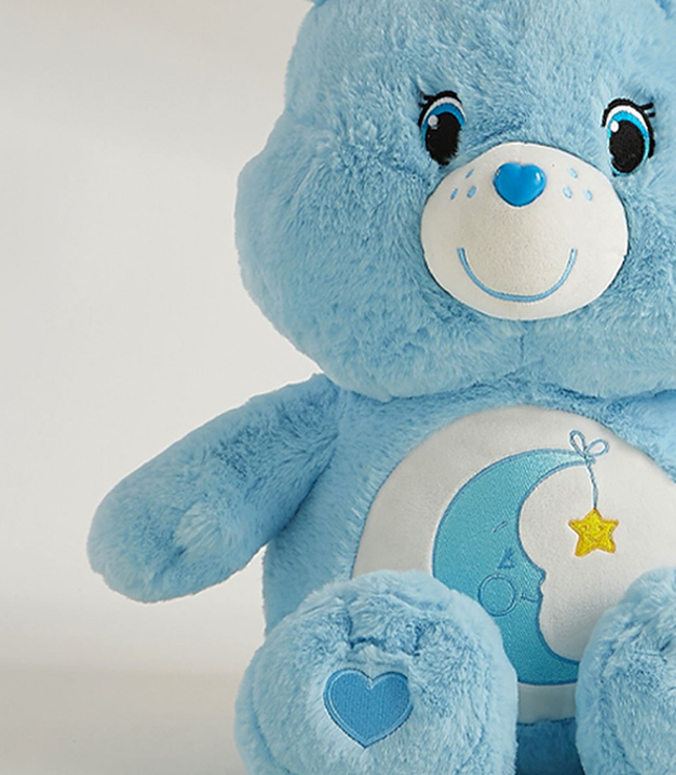 Soft blue plush bear with moon and star embroidery, perfect for snuggles and bedtime comfort.