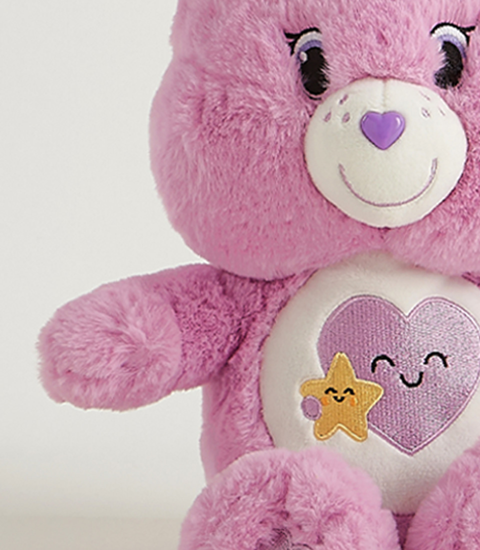 Soft and cuddly pink plush bear with a heart and star design on its belly, perfect for kids and collectors.