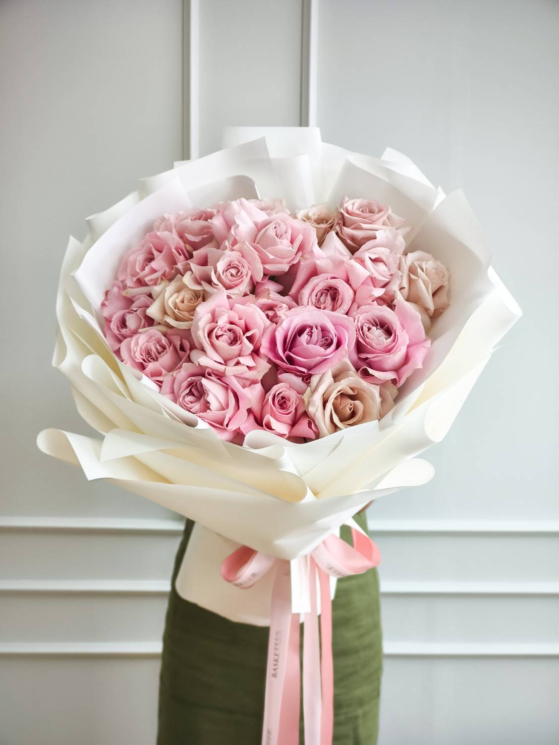 Elegant bouquet of premium pink and cream roses wrapped in white paper with pink satin ribbon, luxury romantic flower gift Bangkok