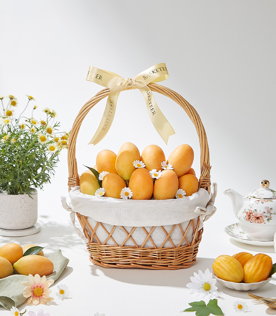 A beautiful handwoven wicker basket, lined with soft fabric, filled with 1.5 kg of fresh, golden Mayongchid (Marian Plum), decorated with white daisies and a luxurious gold ribbon—a perfect gift for any occasion.