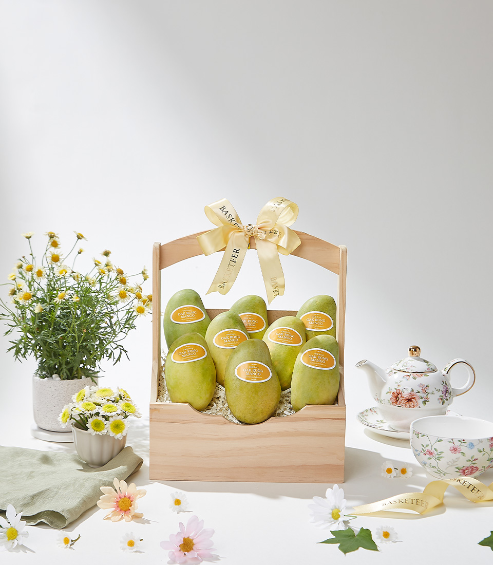 A beautifully handcrafted woven basket filled with premium Mayongchid (Marian Plum) fruit, elegantly decorated with a satin ribbon, exuding sweet tropical flavors and a delicate aroma.