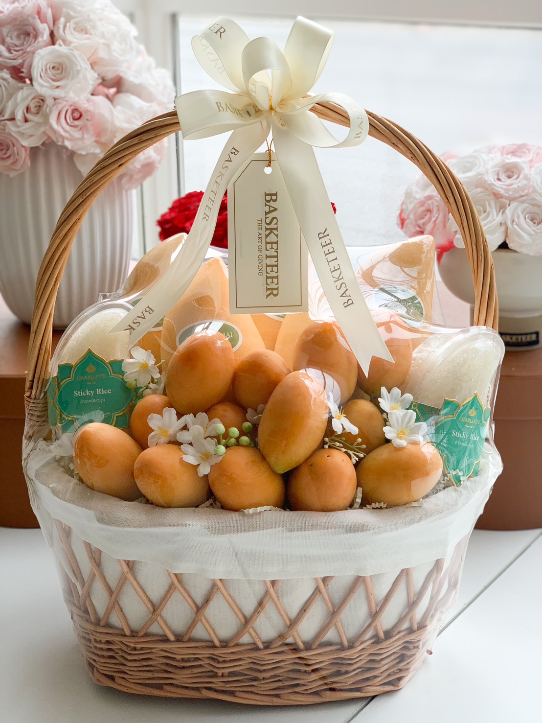 Premium mango sticky rice gift basket with white floral accents.