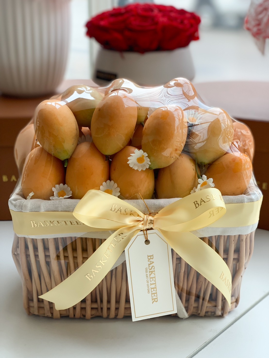 Premium Mayongchid gift basket wrapped in clear cover with elegant yellow ribbon and floral accents.