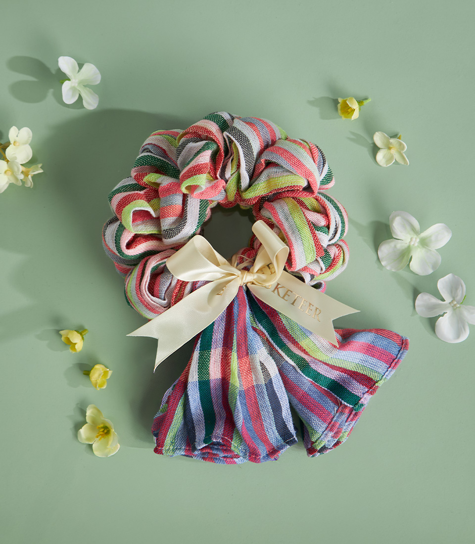 Traditional Thai loincloth garland in multicolour design with cream ribbon on green background.