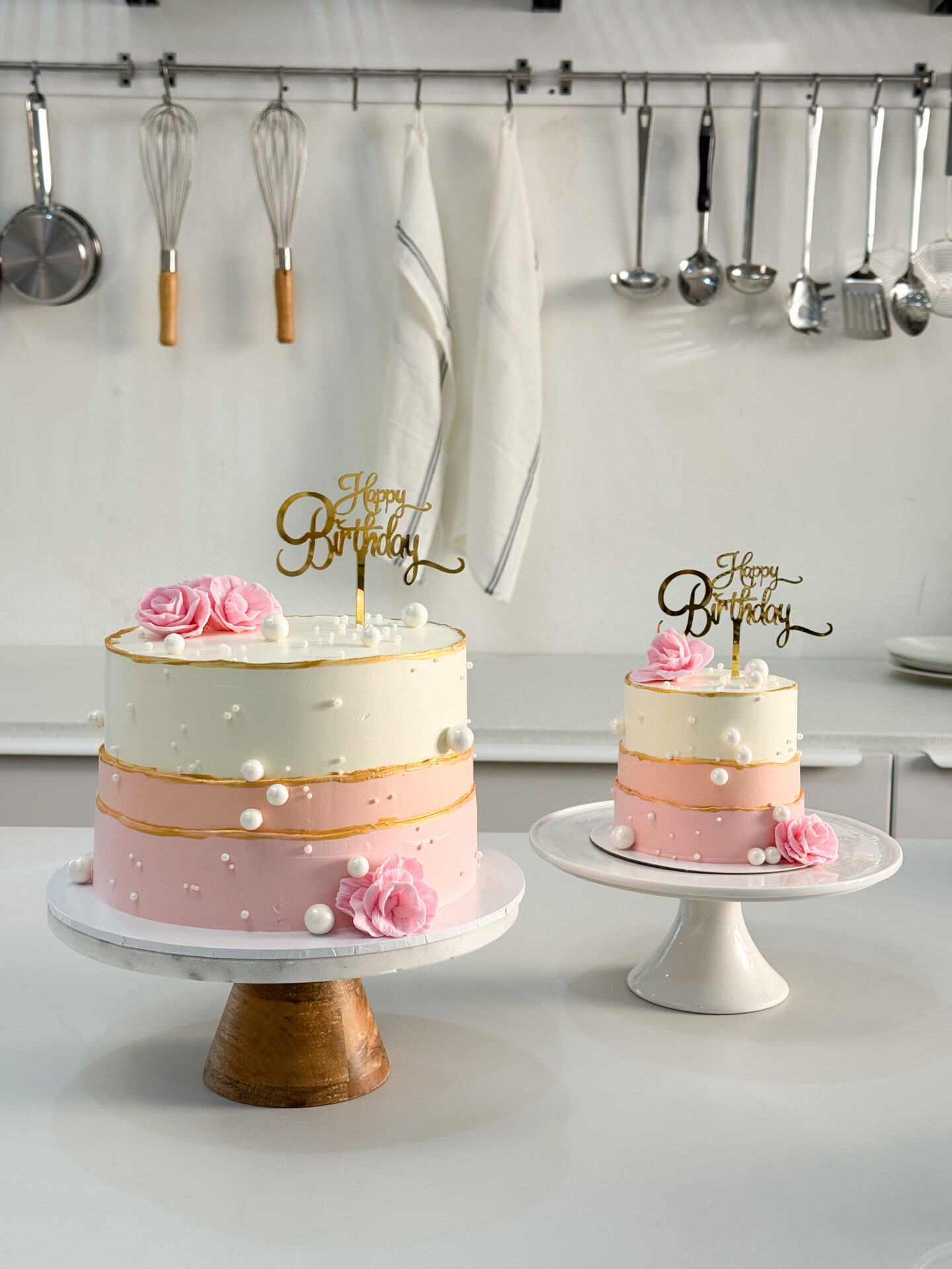 Elegant birthday cake set in pink and white with pearl decorations and pink rose toppers.