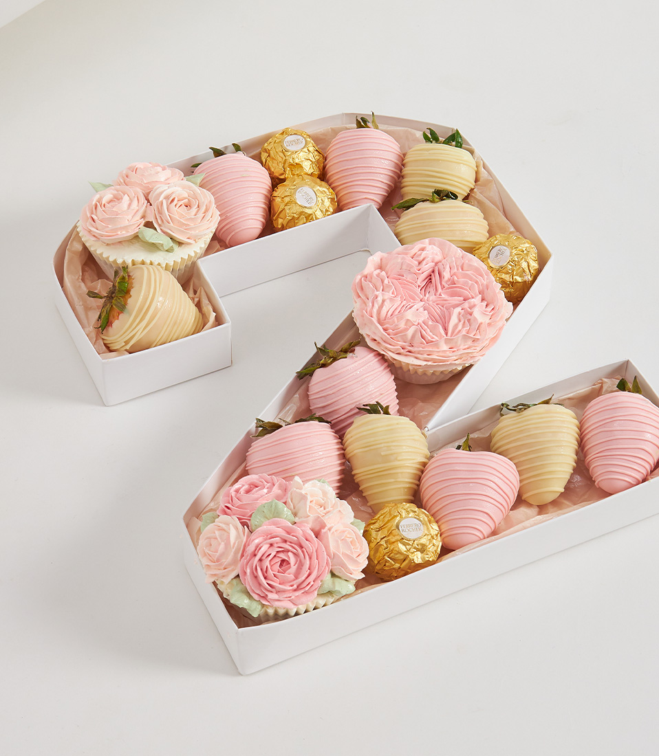 Number 2 chocolate strawberry box with pastel tones, flower cupcakes, and Ferrero Rocher on soft pink paper