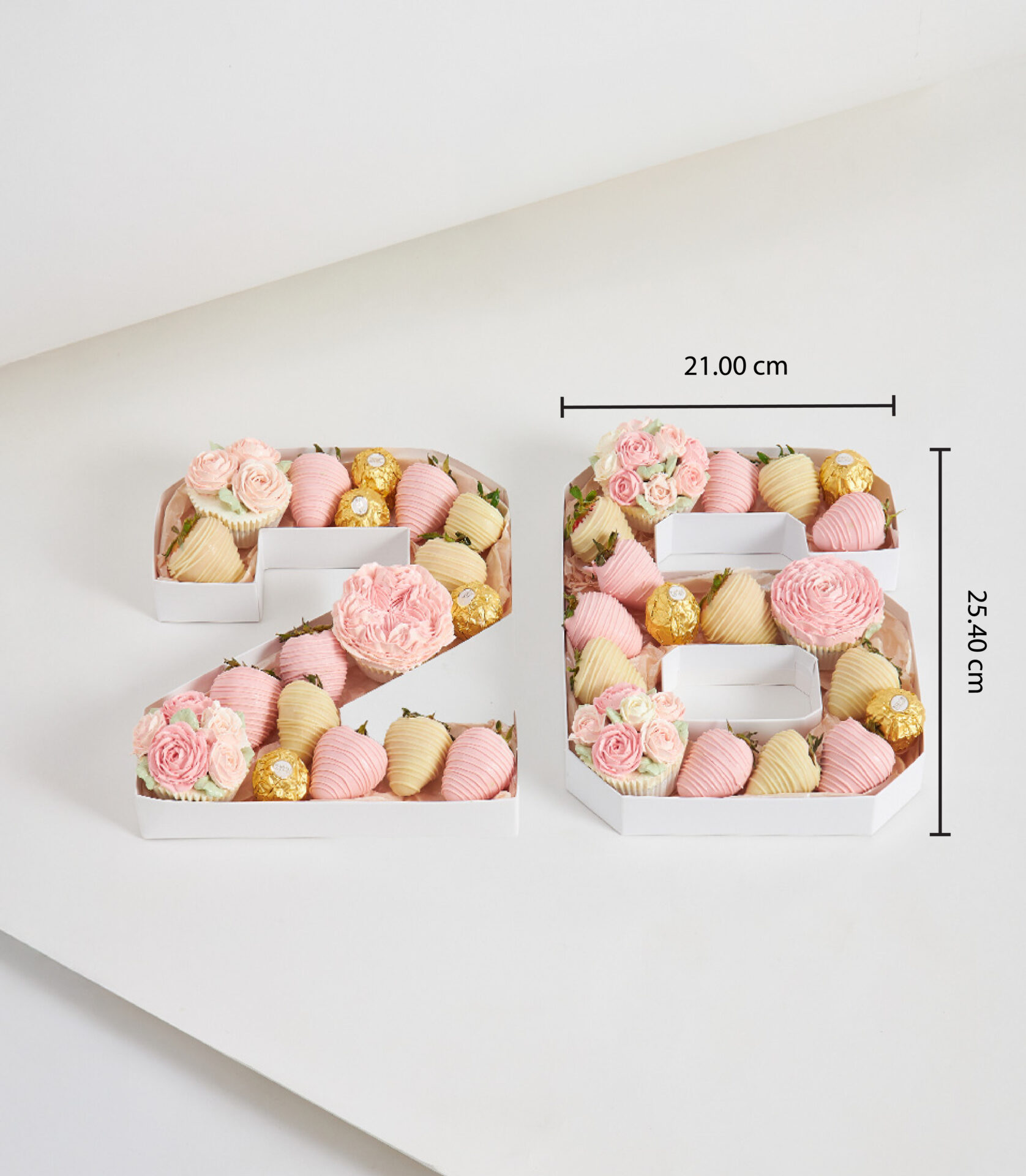 Pastel pink and cream number 26 box with chocolate-dipped strawberries, buttercream flower cupcakes, and Ferrero Rocher