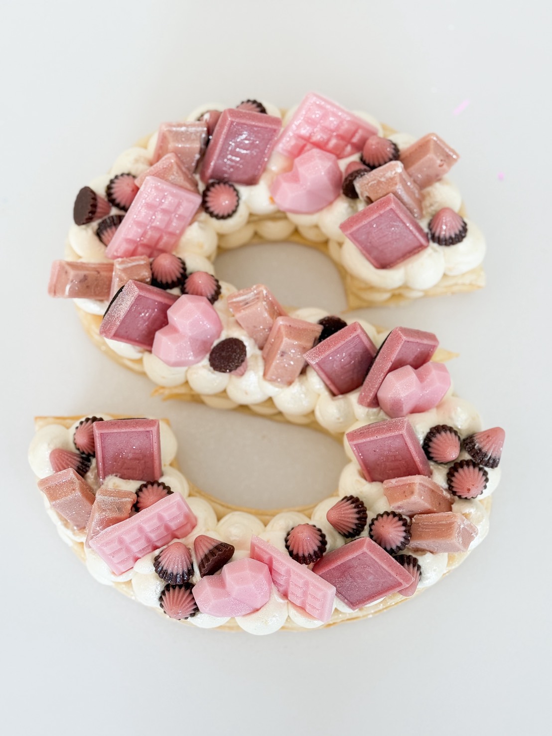 A Sweet Pink Puff Letter Cake shaped like an 