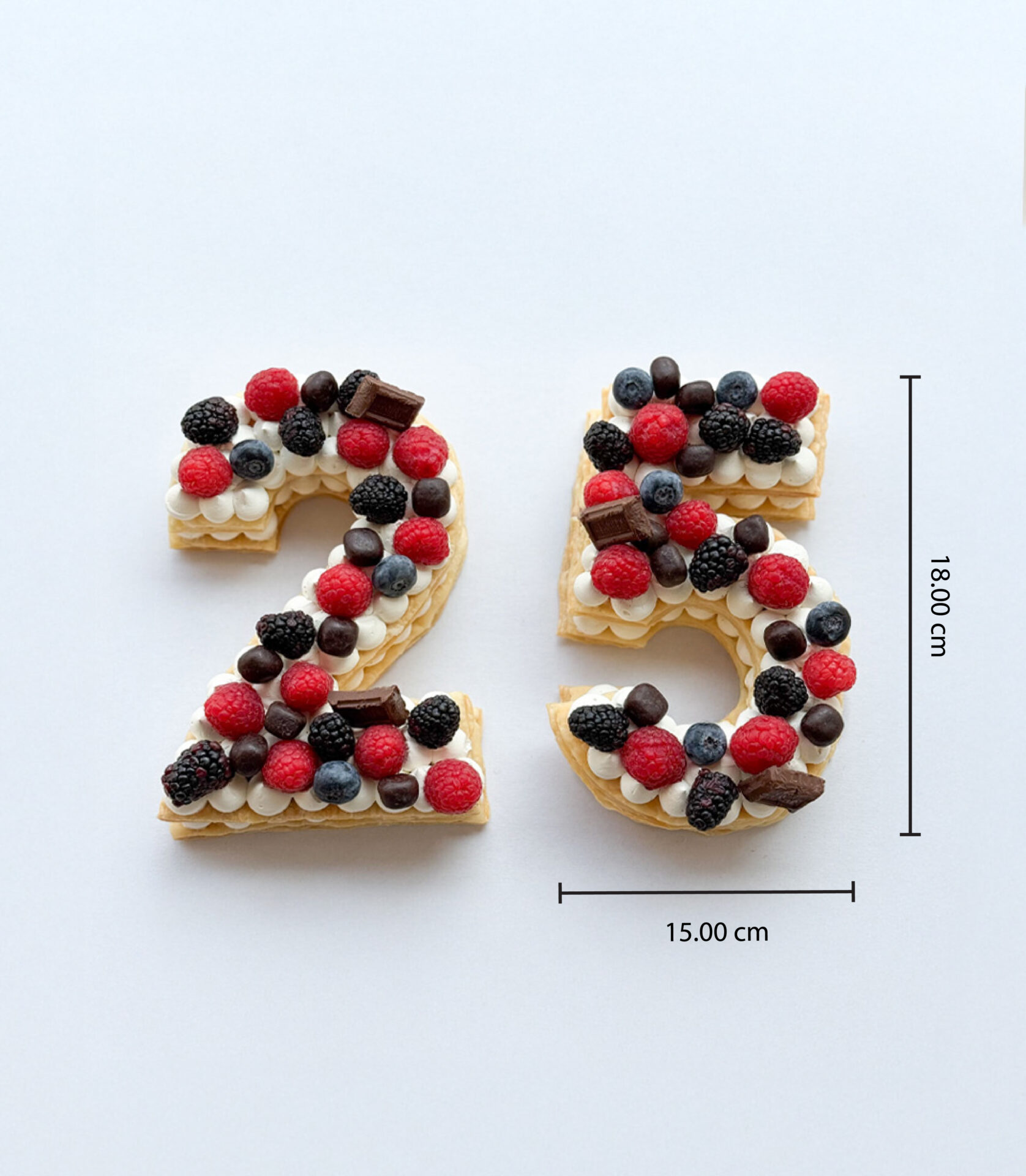 Number 25 puff pie cake topped with fresh berries and chocolates