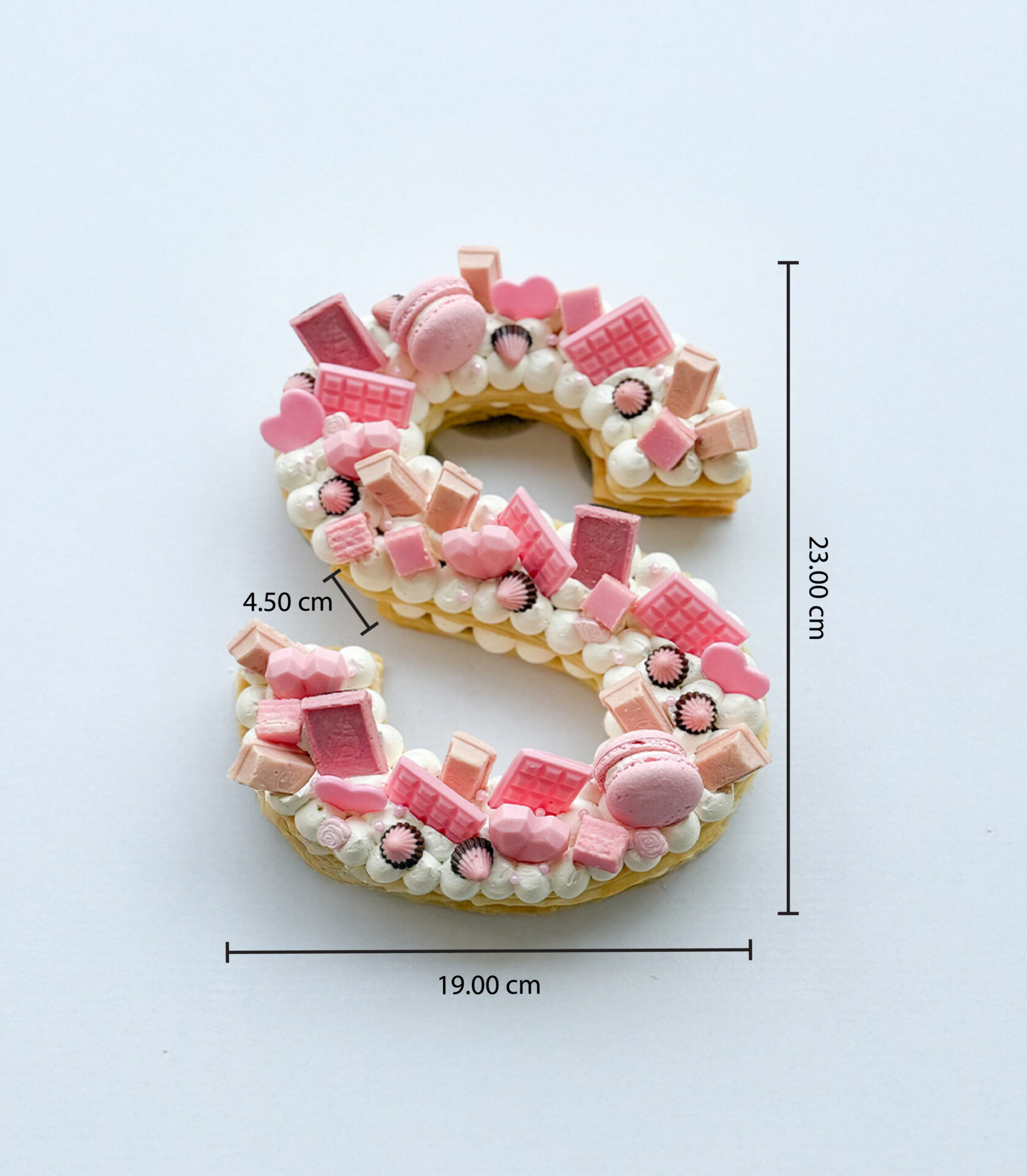 Sweet pink puff letter cake with strawberry chocolate, macarons, and heart toppings