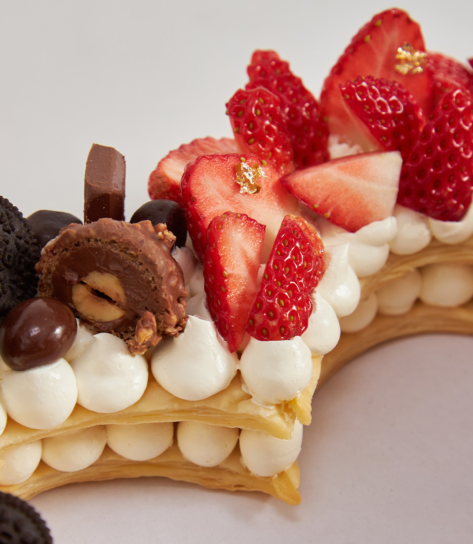 Heart-shaped puff pie cake topped with Japanese strawberries, chocolates and cookies