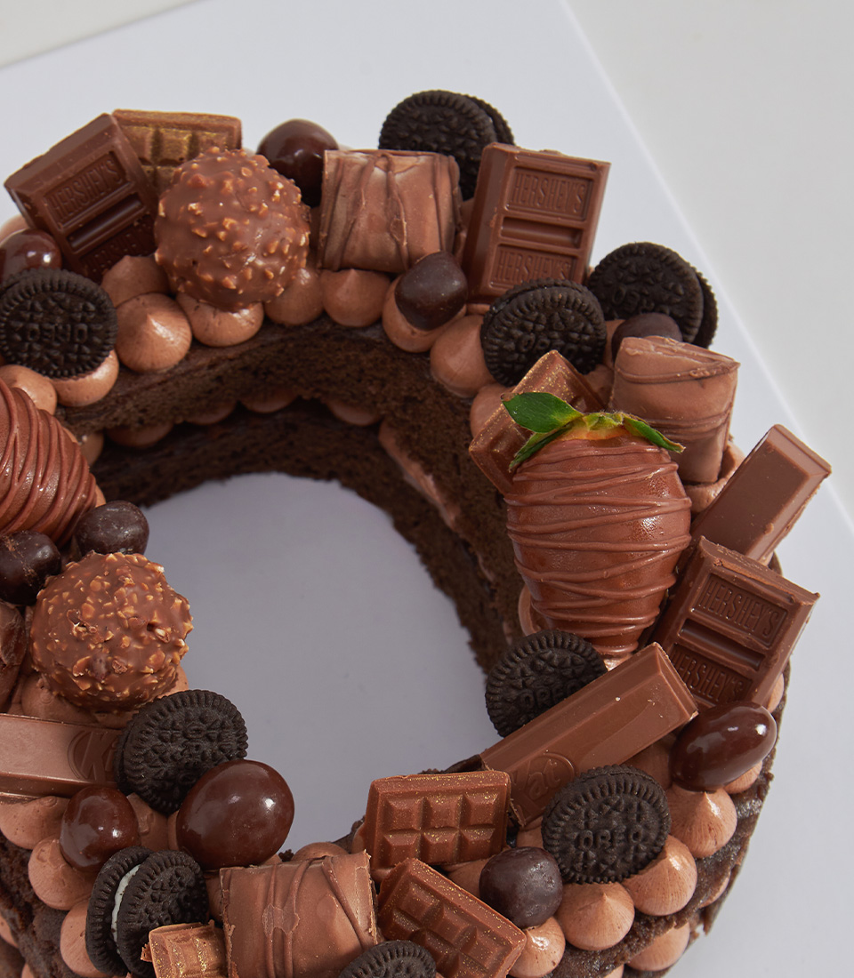 Chocolate letter cake topped with assorted chocolates and chocolate-dipped strawberries