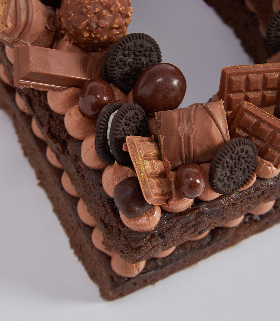 Chocolate letter cake topped with assorted chocolates and chocolate-dipped strawberries