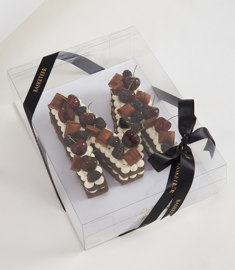 Chocolate letter M cake with cherries, blackberries, Kinder Bueno, and Hershey's chocolate