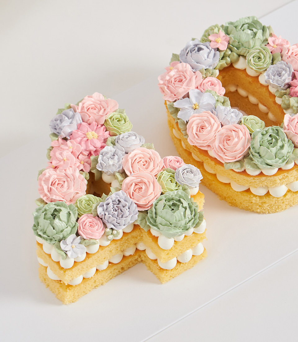 Number 40 vanilla sponge cake decorated with pastel buttercream flowers