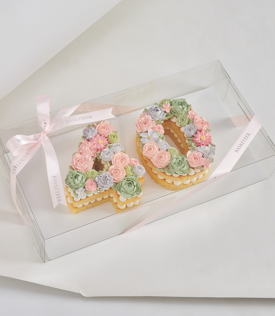 Number 40 vanilla sponge cake topped with pastel buttercream flowers in pink, green, and lavender