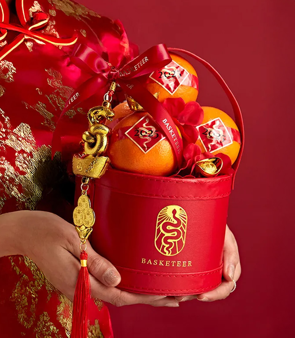 Chinese New Year red gift basket with lucky oranges and golden decorations