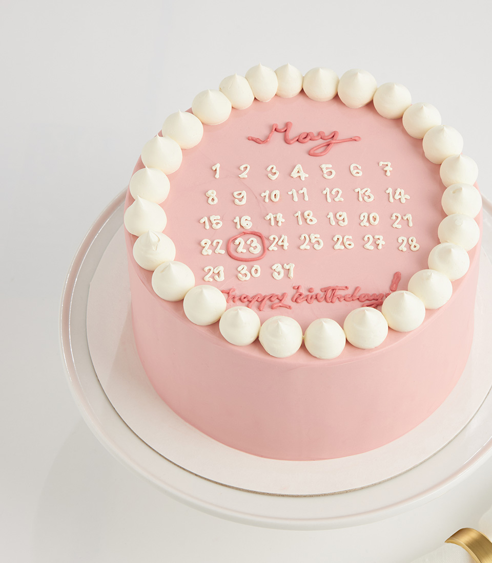 Pink birthday calendar cake with buttercream border and date highlight