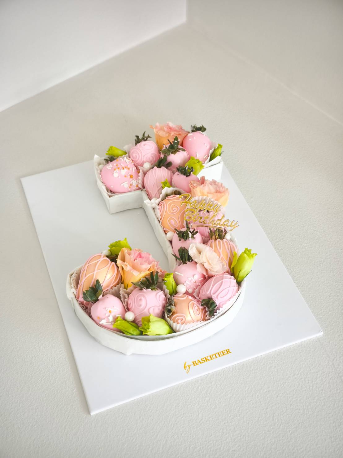 Letter S cake decorated with pastel pink chocolate-dipped strawberries, fresh roses, and edible pearls, perfect for birthday celebrations