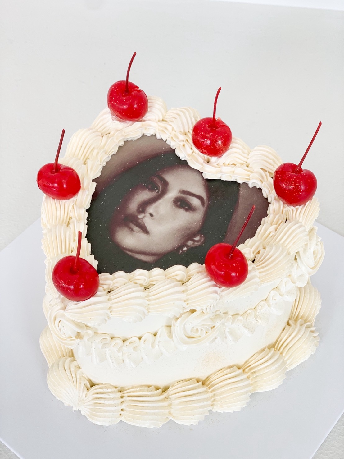 Vintage-style photo cake with heart-shaped cream frame and red cherries on top