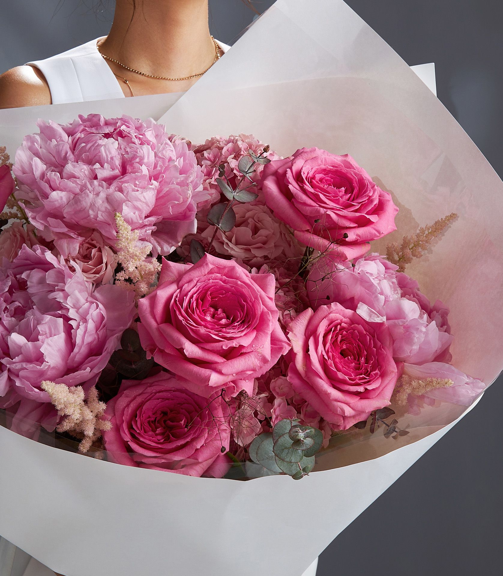 Close-up of pink Nuage roses and Dutch peonies with hydrangeas, astilbe, eucalyptus, and cotinus in luxury bouquet