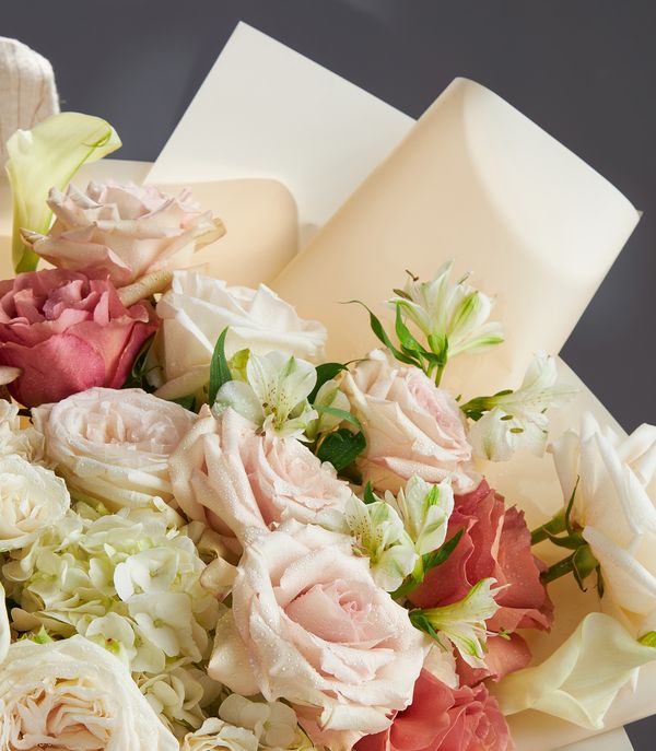 Elegant bouquet of blush and ivory Ecuadorian roses, accented with white alstroemeria, hydrangeas, and cream wrapping.