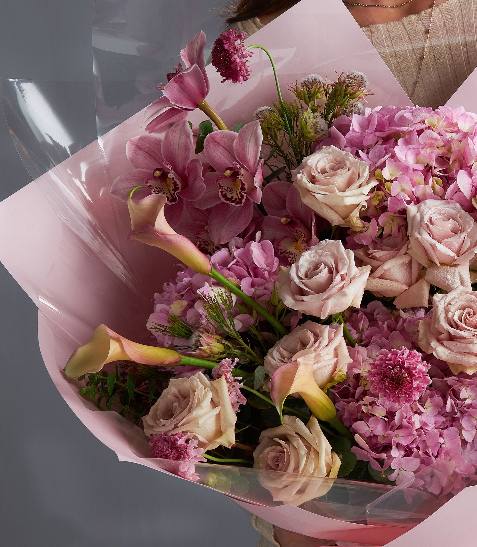 Luxurious pink bouquet featuring Quicksand roses, cymbidium orchids, calla lilies, hydrangeas, and scabiosa.