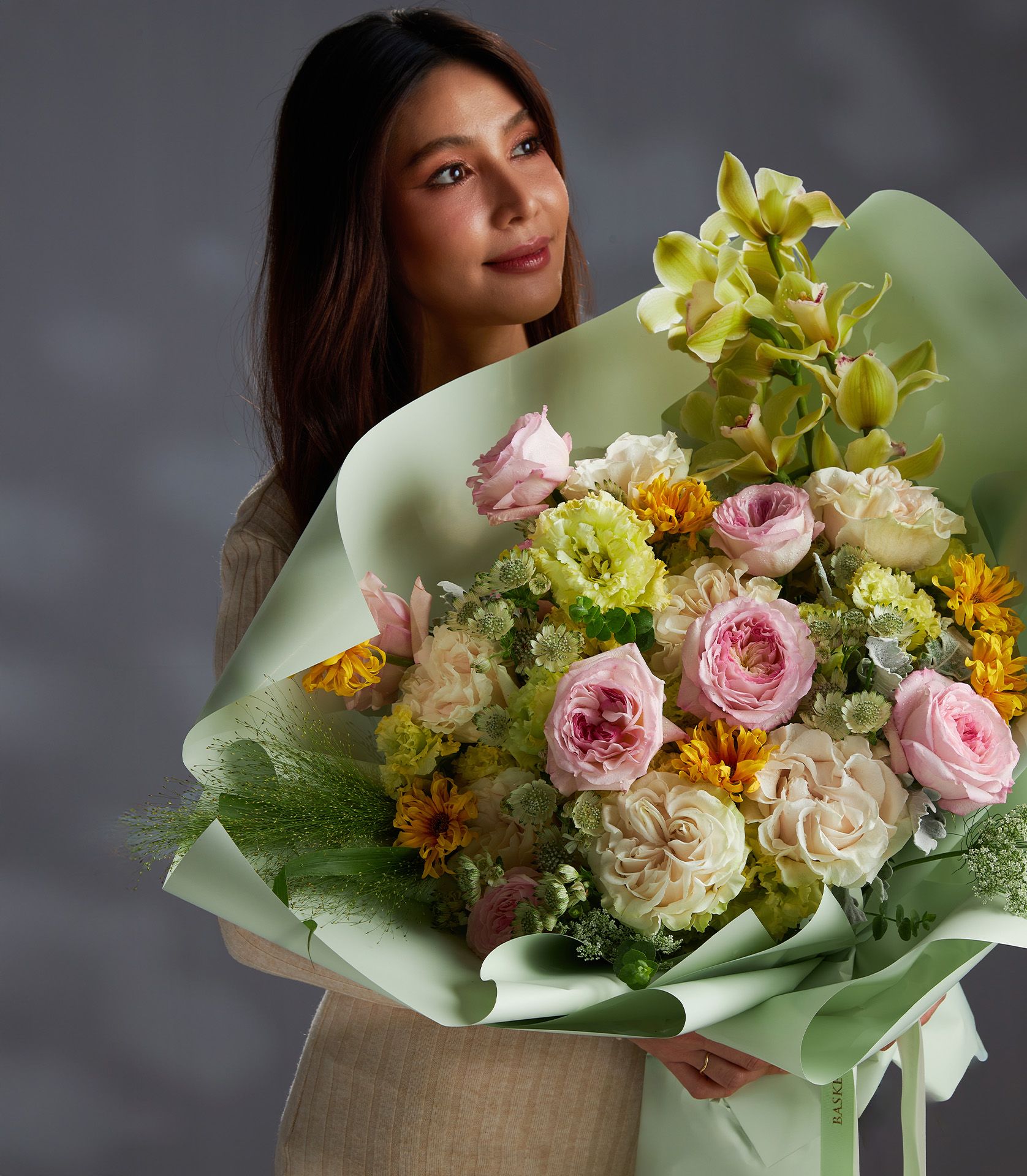 Large pastel bouquet featuring pink Keira roses, Cotton Xpression roses, green cymbidium orchids, yellow gerberas, and lisianthus.