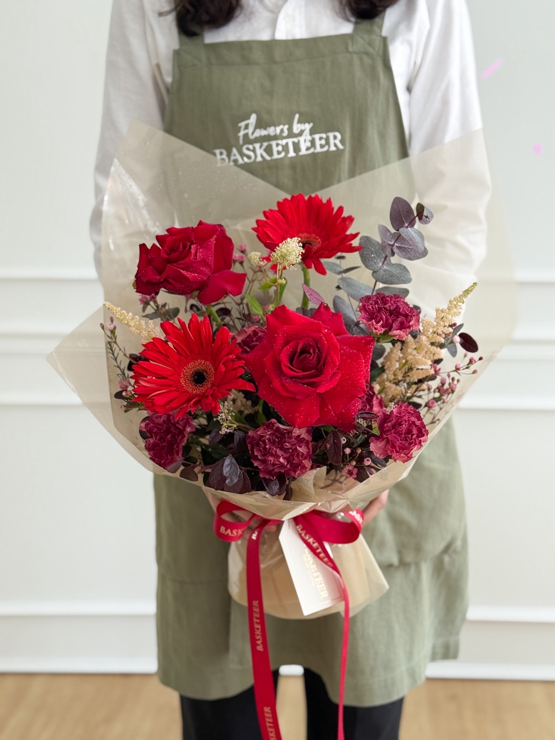 A person wearing a green apron with 