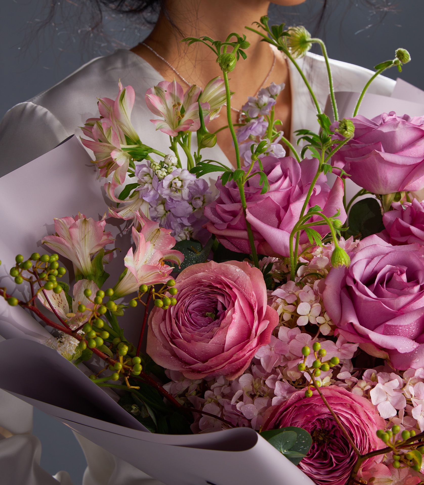 Elegant bouquet with Cool Water roses, Peonikiss roses, pink hydrangeas, alstroemeria, purple stock, and green berries.