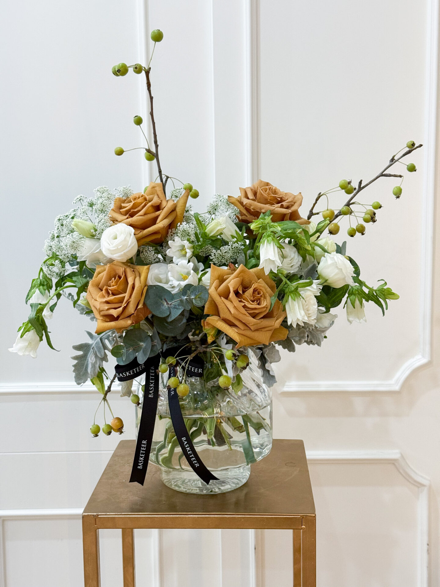 Luxury vase arrangement with golden toffee roses, white lisianthus, queen anne’s lace, eucalyptus, and green berry accents.