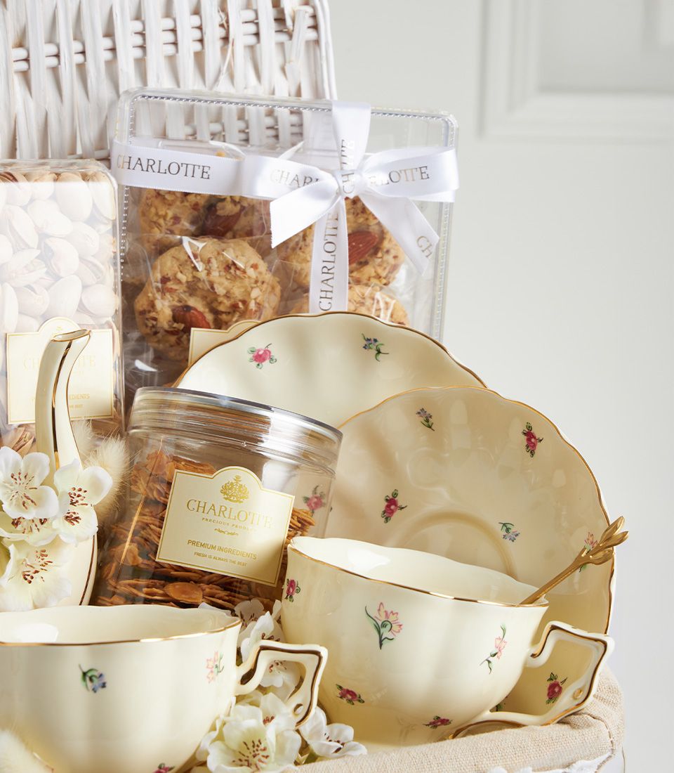Close-up of Charlotte floral tea set gift basket with almond cookies, almond sliced cookies, and roasted pistachios