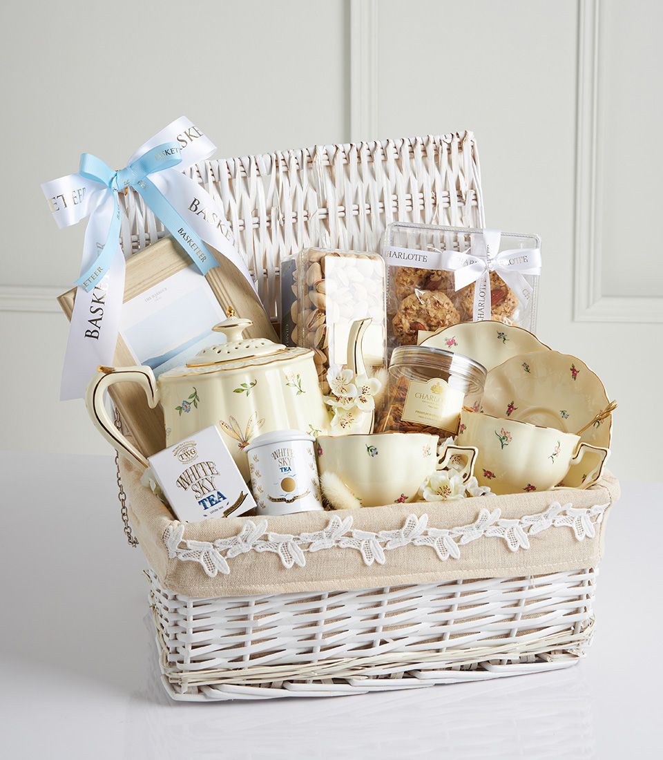Vintage floral tea gift basket with TWG White Sky Tea, Charlotte cookies, roasted pistachios, and an elegant tea set