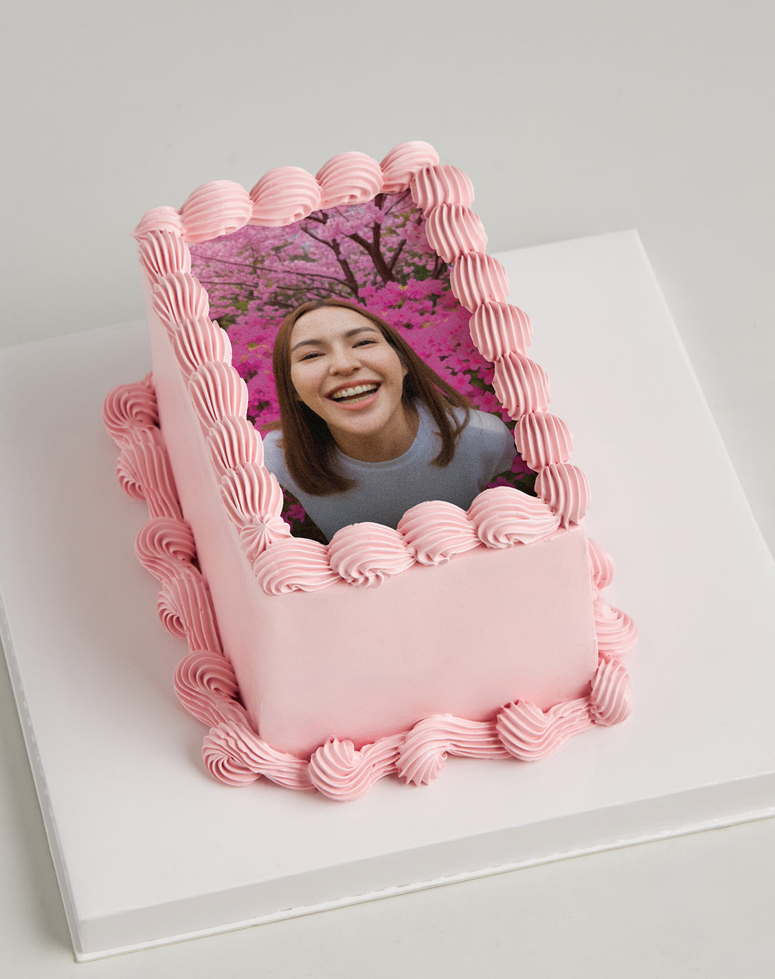 Rectangular pink photo cake with custom edible image and pink piped cream borders.