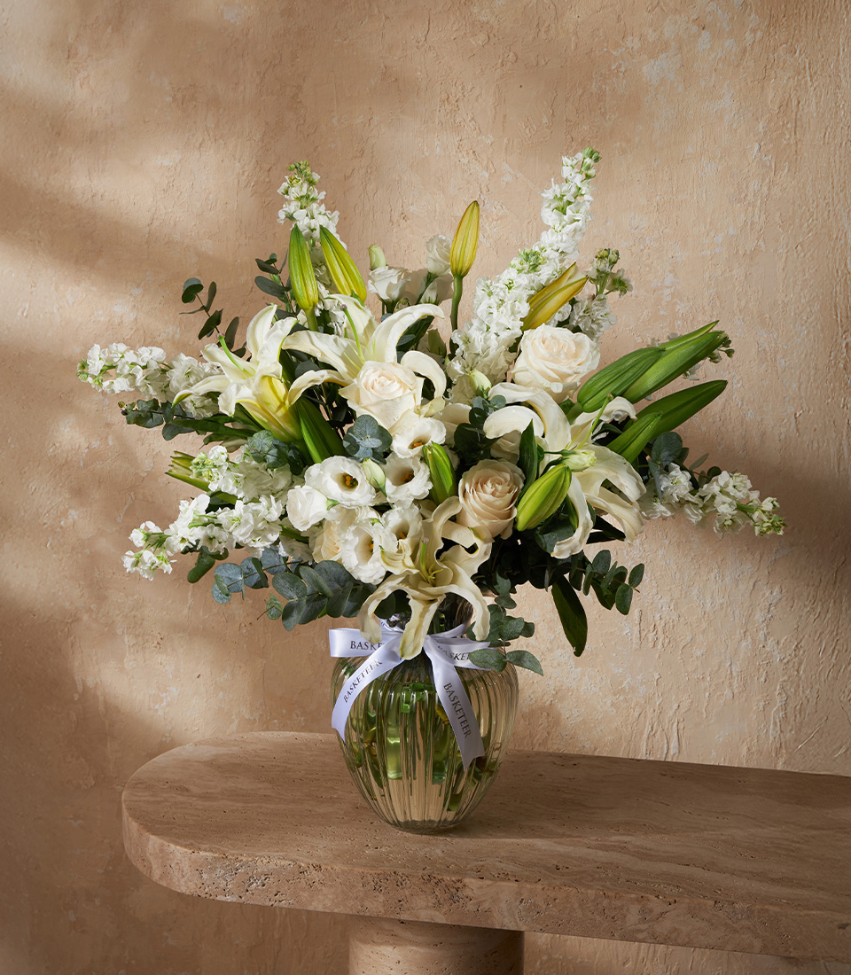 Elegant flower arrangement with white lilies, roses, and lisianthus in a glass vase, perfect for luxury gifts and Bangkok flower delivery.