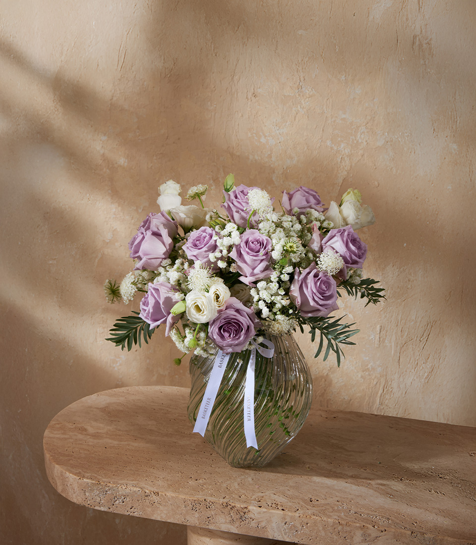 Elegant flower arrangement with lavender roses and white blooms in a glass vase, perfect for luxury flower delivery in Bangkok.