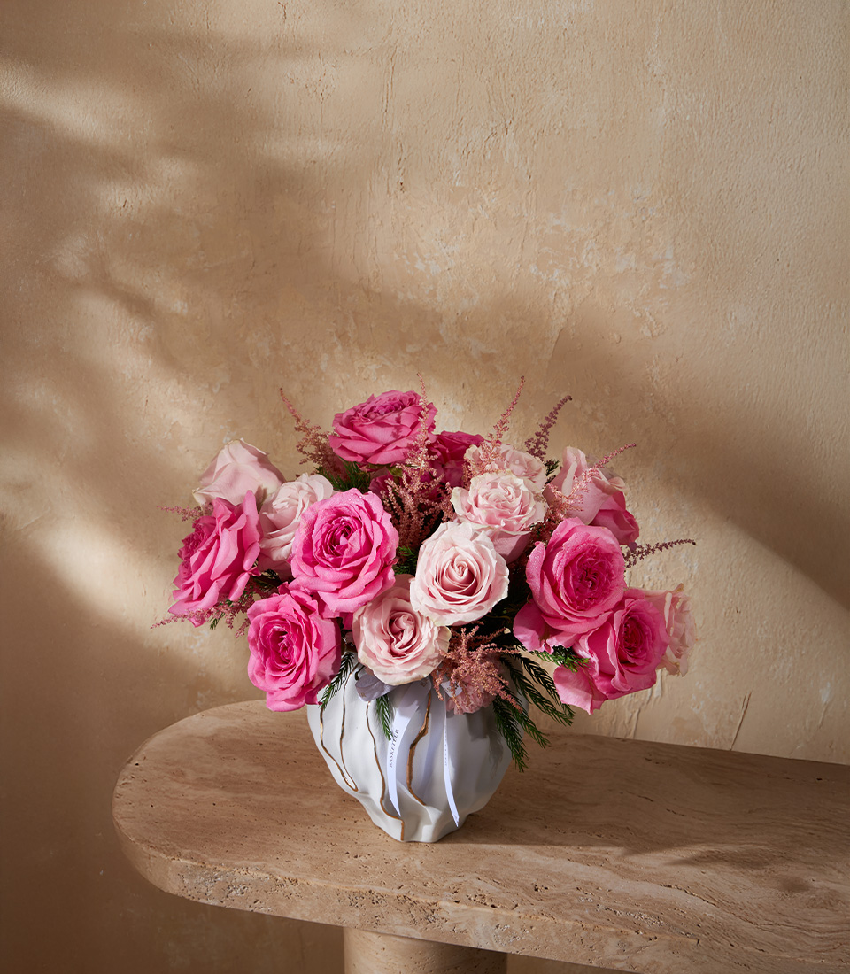 Luxury flower arrangement with pink roses and astilbe in a modern ceramic vase
