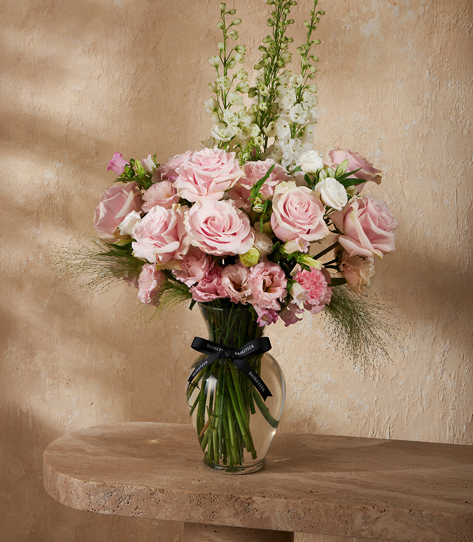 Flower arrangement with soft pink roses, lisianthus, and white blooms in a clear vase – romantic floral gift Bangkok.