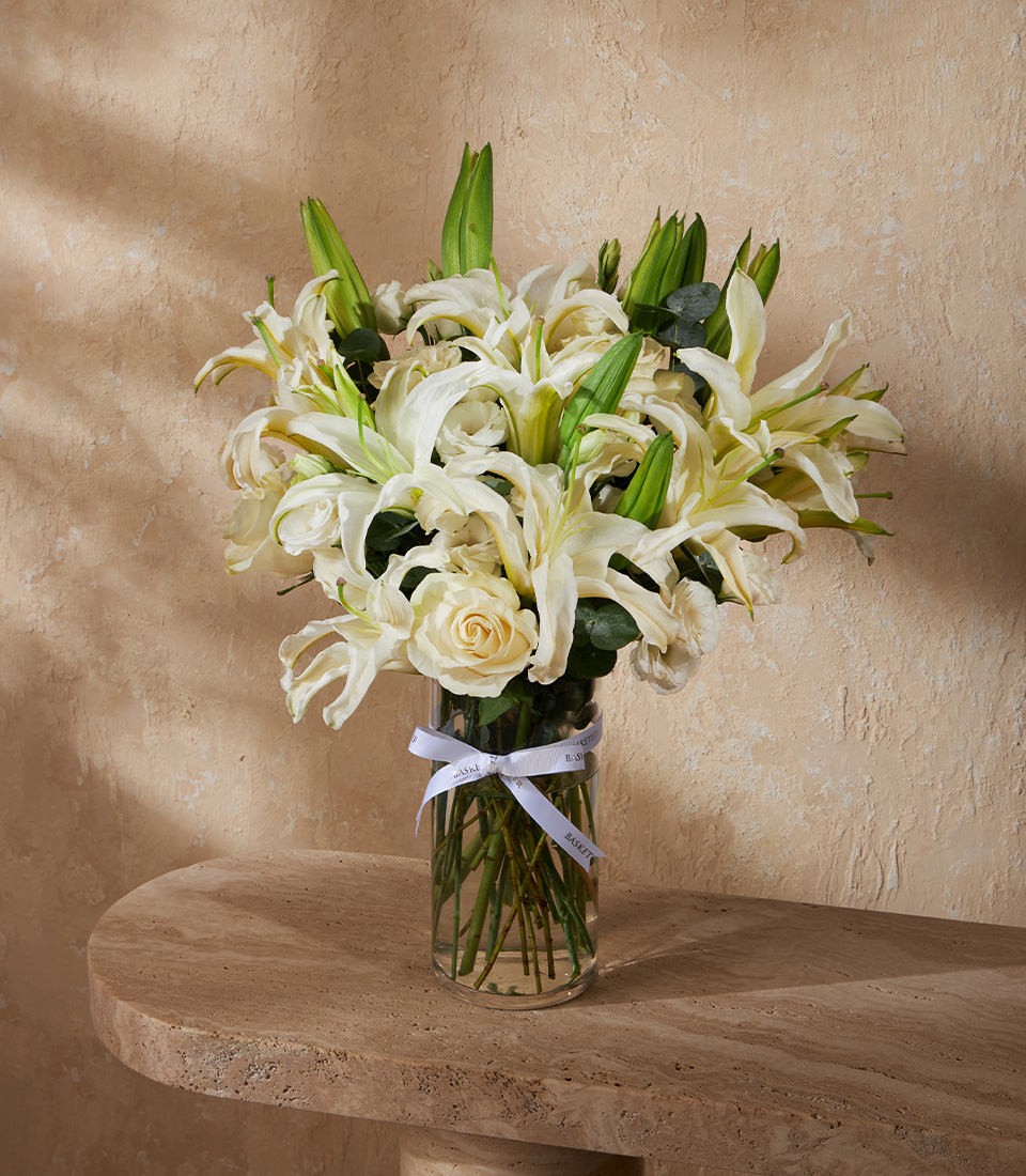 Elegant vase arrangement with white lilies and roses, styled with lush greenery. A premium floral gift for Bangkok delivery.