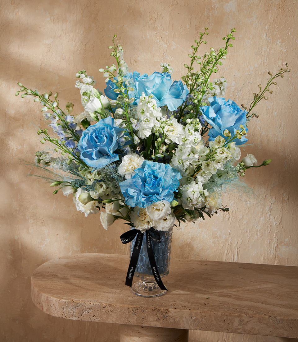 Flower vase arrangement with blue roses and white flowers in elegant style