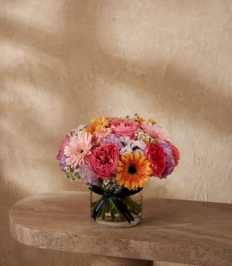 Elegant flower arrangement with pink gerberas garden roses orange gerbera purple hydrangeas and chamomile in a glass vase Bangkok delivery