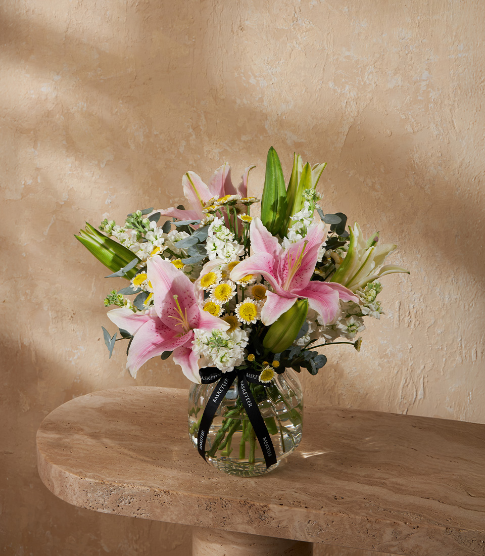 Elegant flower arrangement with pink gerberas garden roses orange gerbera purple hydrangeas and chamomile in a glass vase Bangkok delivery