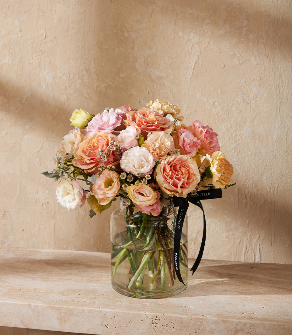 Vase arrangement of peach and blush garden roses with lisianthus and carnations Perfect romantic flower gift for birthdays anniversaries or luxury delivery in Bangkok