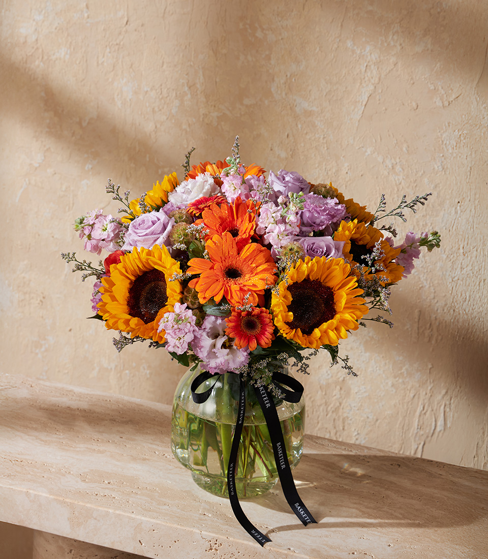 Vase with sunflowers orange gerberas lavender roses and seasonal blooms Bright and colourful arrangement for birthdays anniversaries and Bangkok flower delivery