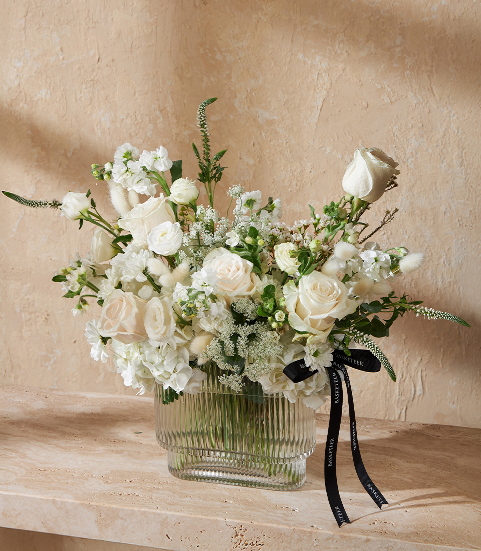 Elegant vase of white roses and hydrangeas in a ribbed glass vase Perfect wedding anniversary or luxury flower delivery arrangement in Bangkok
