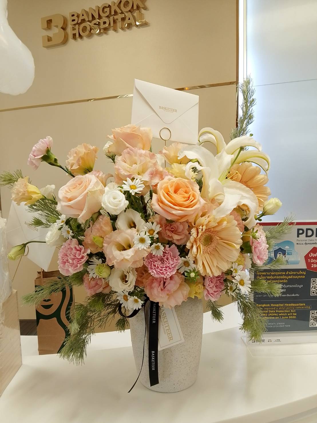 Peach and pink flower arrangement in a vase with roses, lilies, and gerberas — luxury flower delivery in Bangkok by Flowers by Basketeer.