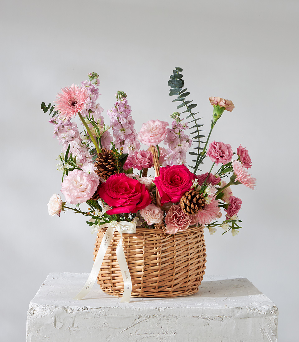 Flower arrangement basket with red roses pink carnations chrysanthemums and pinecones for premium delivery in Bangkok