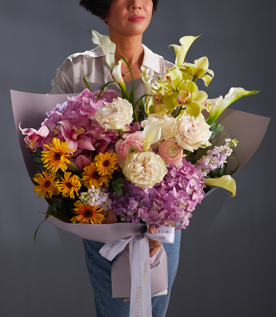 Bouquet of white roses pink ranunculus yellow gerberas orchids and pastel hydrangeas for premium flower delivery in Bangkok